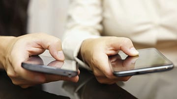 two hands operating mobile phones